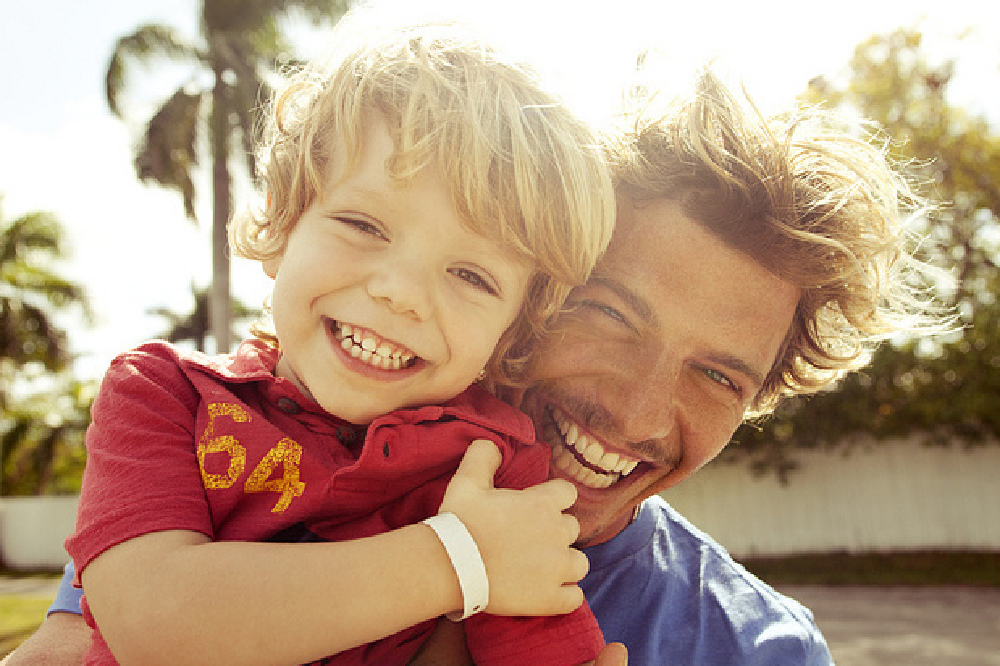 Father and son hugging, laughing,